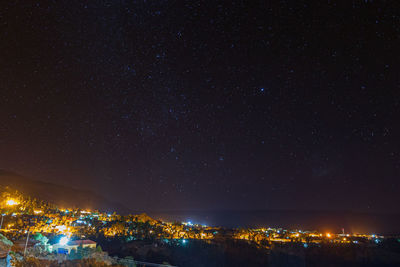 Illuminated city against sky at night