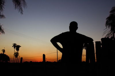 Silhouette people standing against sky during sunset