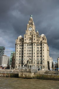 Low angle view of buildings against cloudy sky