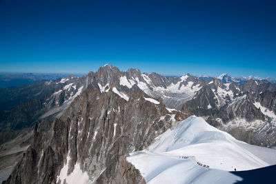 Scenic view of snowcapped mountains against clear blue sky