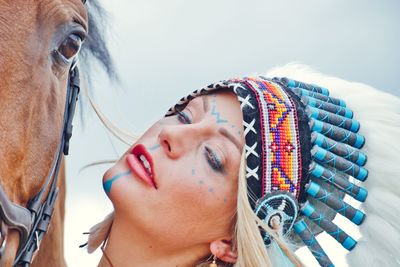 Close-up of woman looking away with horse