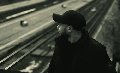 Side view of young man standing on railroad track