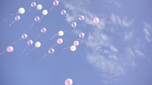 Low angle view of balloons flying against sky