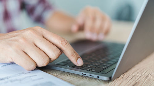 Midsection of man using mobile phone on table