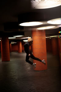 Woman jumping in illuminated garage