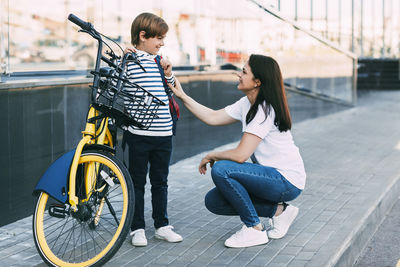 Rear view of mother and son on bicycle