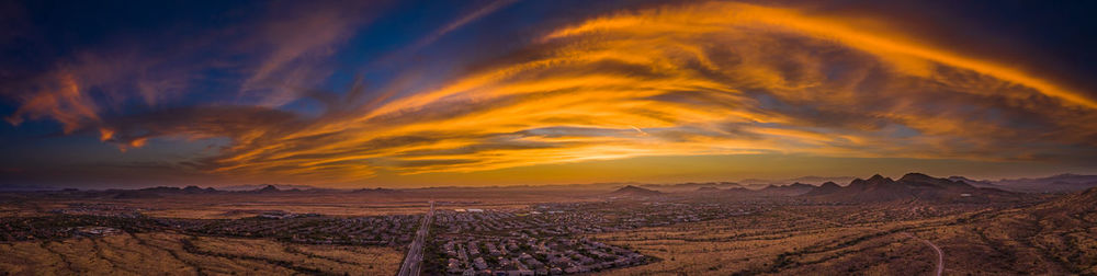 Scenic view of dramatic sky over land during sunset