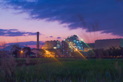 Panoramic view of illuminated field against sky at sunset