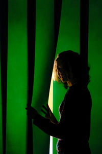 Side view of young woman standing against blurred background