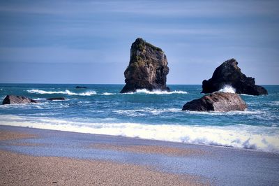 Rock formation on beach against sky