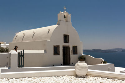 White building by sea against clear sky