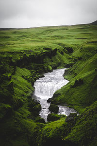 Scenic view of waterfall against sky