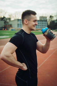 Athlete having water while standing on running track