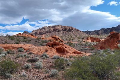 Rock formations in desert against cloudy sky