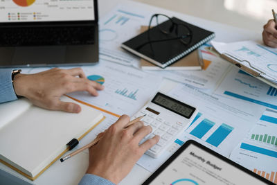 Midsection of business colleagues working on table