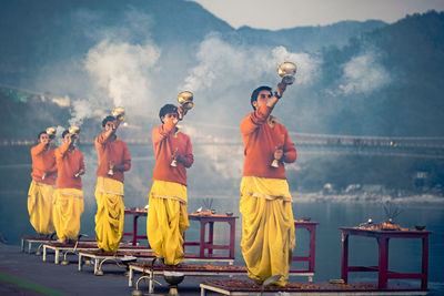 People standing on mountain against sky