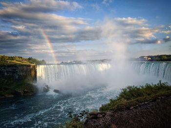 Scenic view of waterfall against sky