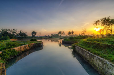 Scenic view of lake against sky during sunset