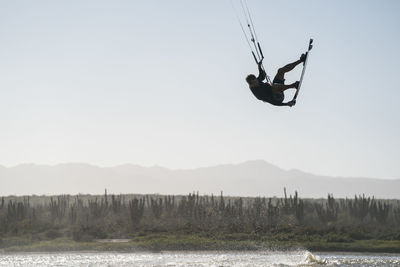 Professional male athlete kiteboarding on a sunny day in mexico