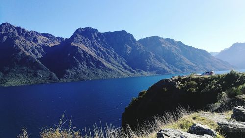 Scenic view of lake and mountains against clear sky