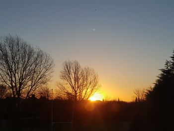 Silhouette bare trees against sky during sunset