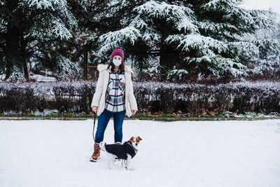 Portrait of smiling young woman standing on snow