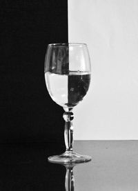 Close-up of wine in glass on table against white background