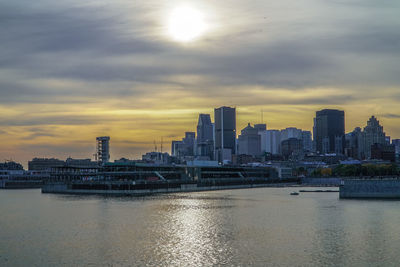 Scenic view of river and cityscape against sky during sunset