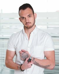 Portrait of young man standing against wall