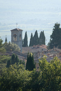 Castle by trees and buildings against sky