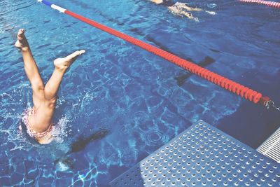 Low section of woman diving in swimming pool