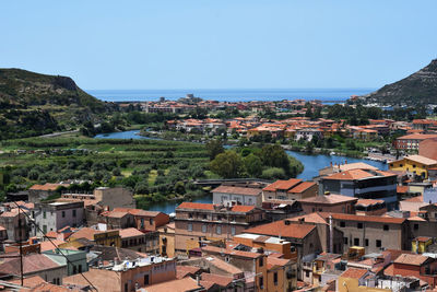 High angle view of townscape by sea against clear sky