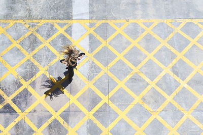 Woman tossing hair while dancing on footpath