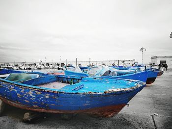 Boats moored on beach against sky