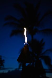 Close-up of illuminated lamp against sky at night