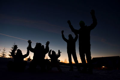 Silhouette people enjoying against sky during sunset