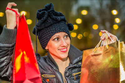 Smiling young woman holding shopping bags