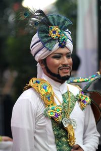 Smiling man wearing traditional clothing during festival