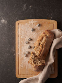 High angle view of hand holding bread on cutting board