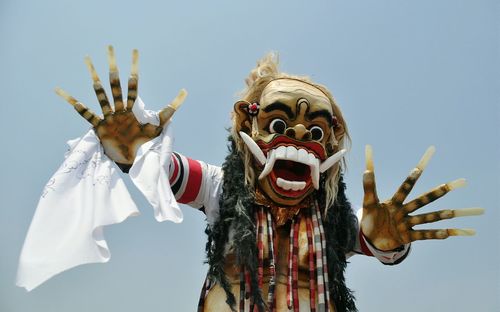 Close-up of person wearing devil costume against sky