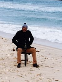 Full length of man sitting on beach