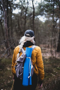 Rear view of woman standing in forest