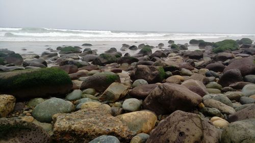 Rocks on beach against sky