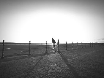 Silhouette people standing on field against clear sky