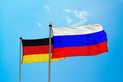 Low angle view of flag against blue sky