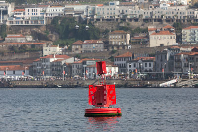 Sailboats in sea against buildings in city