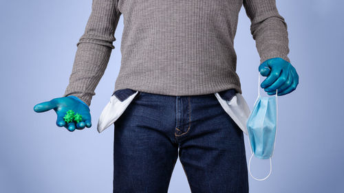 Midsection of man standing against blue background