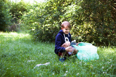 Side view of young man drinking water on field