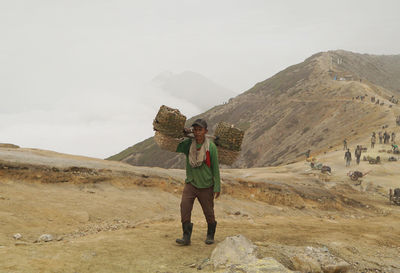 Sulphur miners activity at mount ijen in banyuwangi, indonesia.