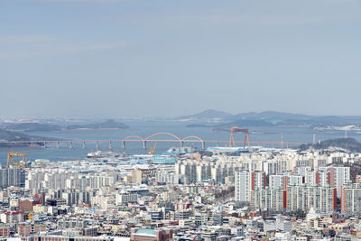 Aerial view of cityscape against blue sky